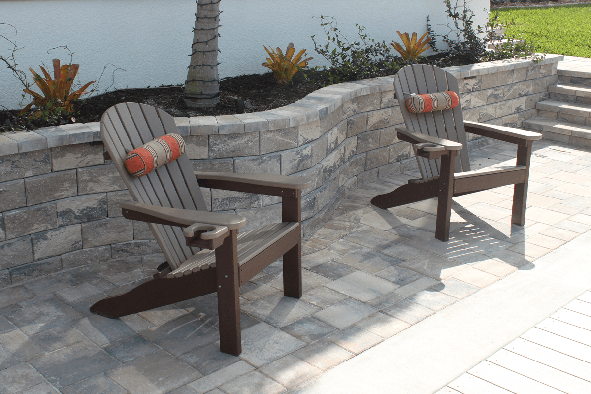 Wall paver collection with a paved floor and wooden beach chairs to relax in near a house