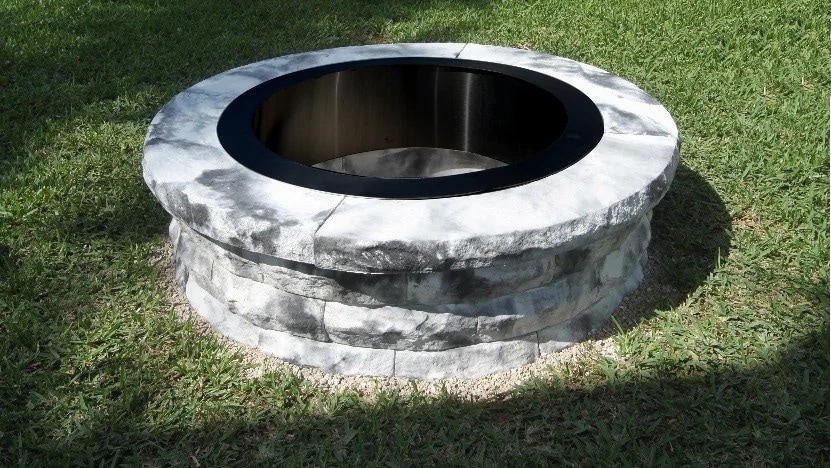 A fire pit built with a metal ring and pavers
